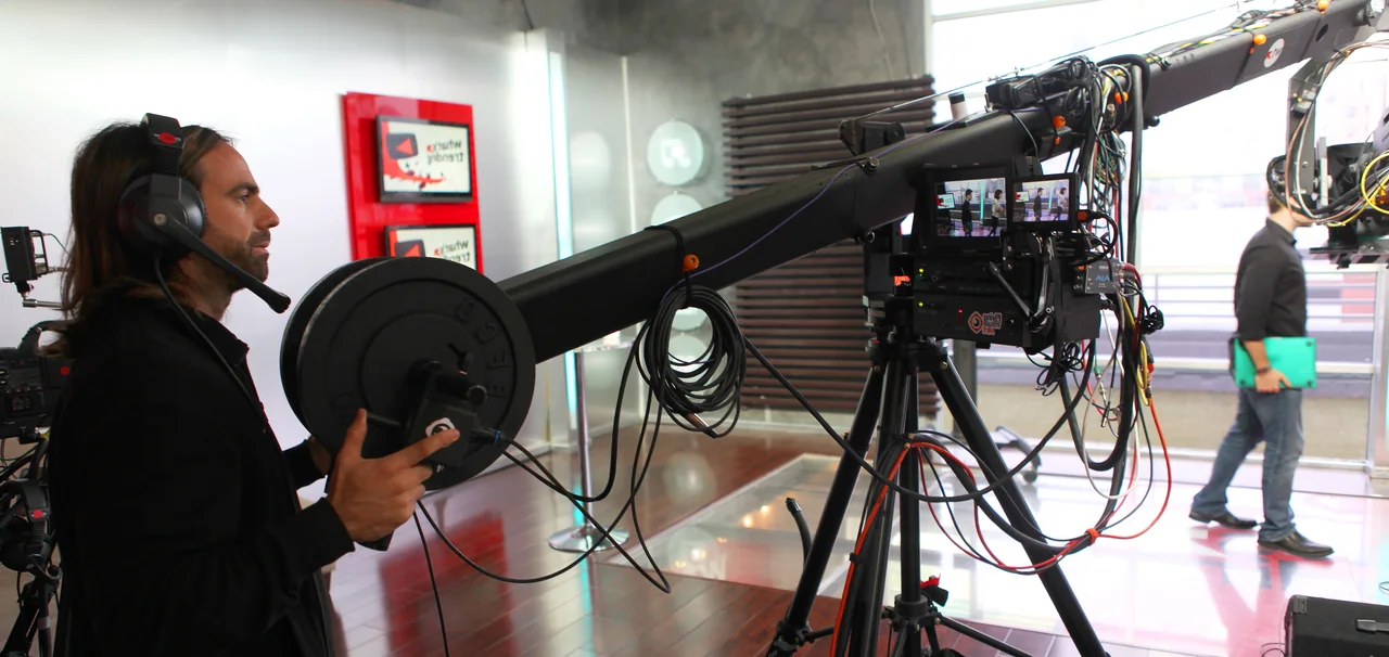 Ariel operating a camera crane inside a professional studio